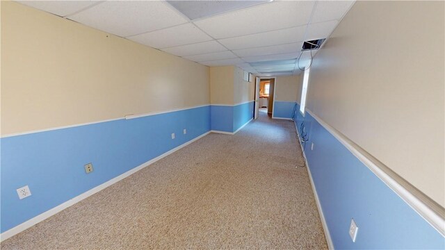 carpeted empty room with a paneled ceiling