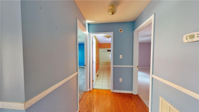 corridor with light hardwood / wood-style floors