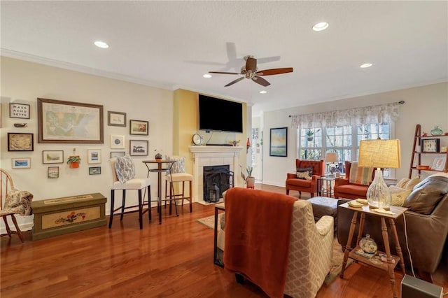living room featuring a ceiling fan, wood finished floors, a fireplace, and recessed lighting