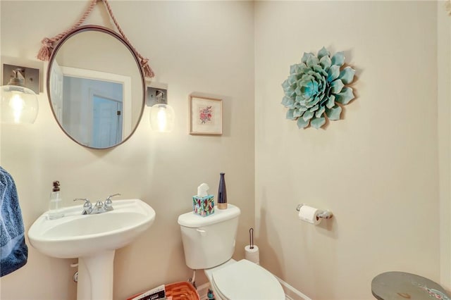 bathroom with baseboards and toilet