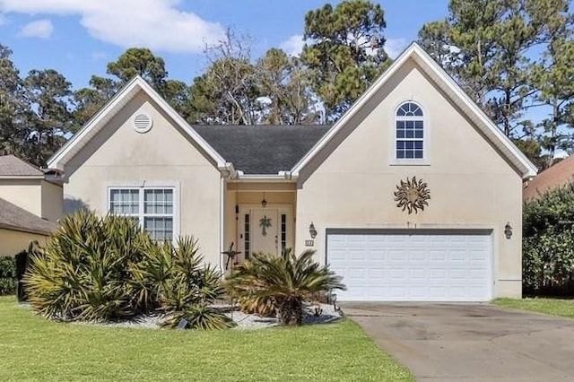view of front of home featuring stucco siding, a garage, concrete driveway, and a front yard