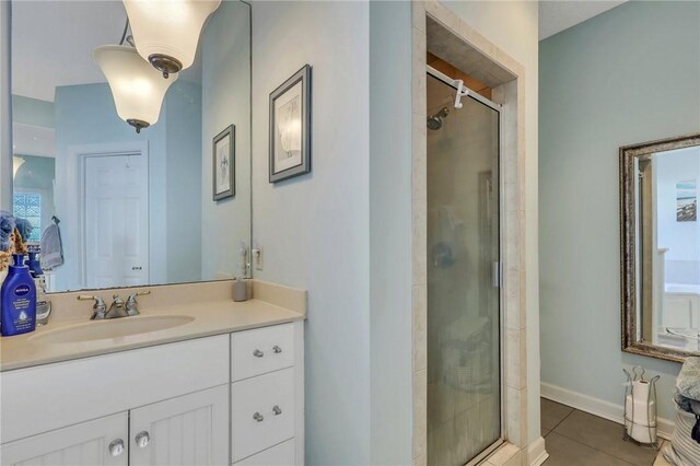 bathroom featuring vanity, tile patterned floors, and a stall shower