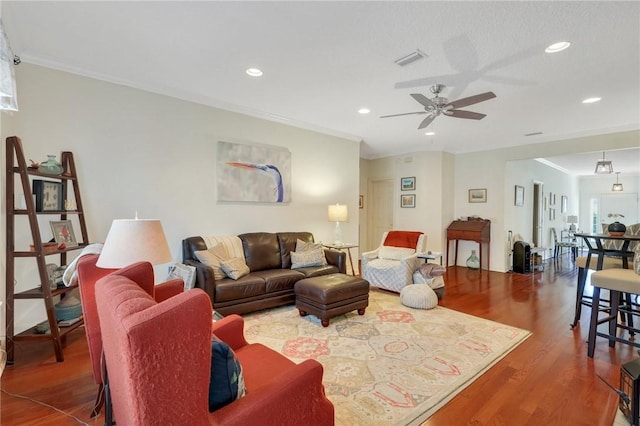 living room with recessed lighting, wood finished floors, visible vents, crown molding, and ceiling fan