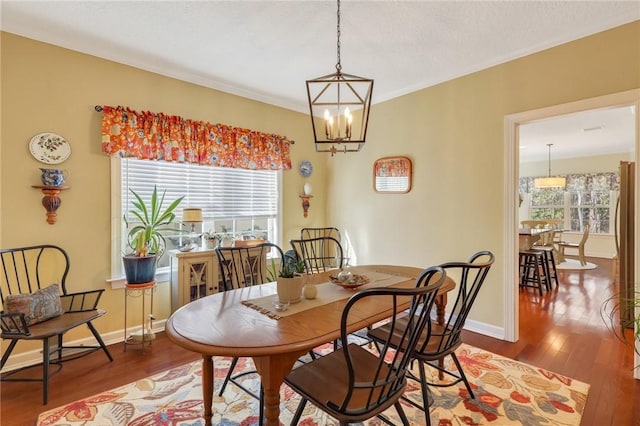 dining area featuring wood finished floors, baseboards, and a notable chandelier