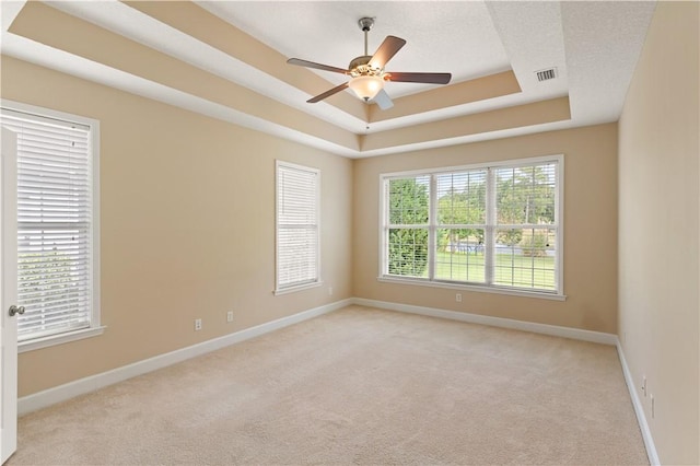 empty room with baseboards, visible vents, and light carpet