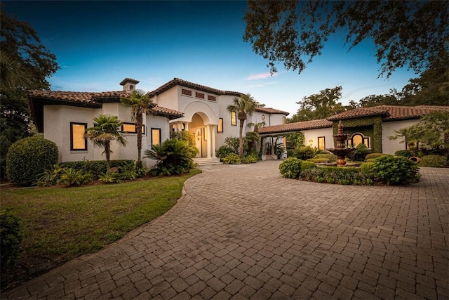 mediterranean / spanish house featuring a front lawn