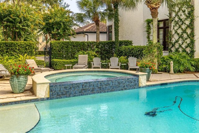 view of swimming pool with an in ground hot tub