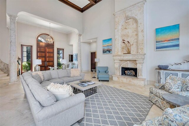 living room featuring ornamental molding, a high ceiling, and decorative columns