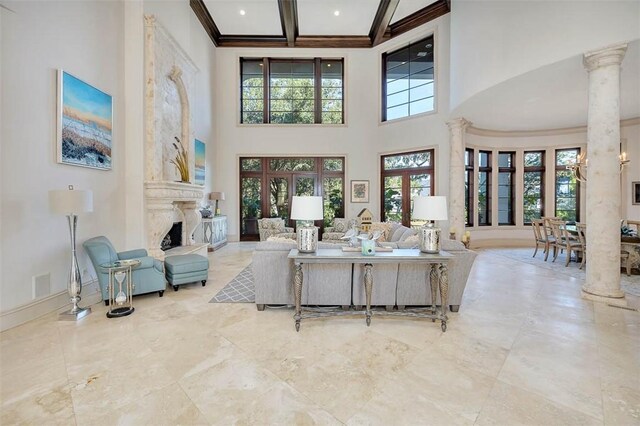 living room with a fireplace, plenty of natural light, a towering ceiling, and french doors