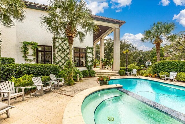 view of swimming pool with an in ground hot tub and a patio