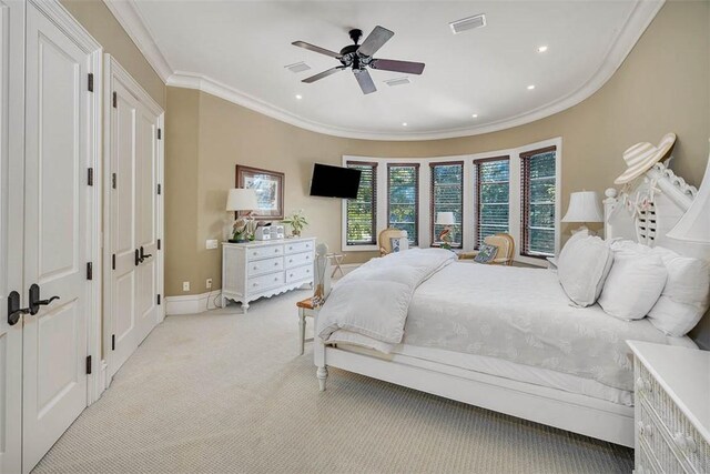 carpeted bedroom with ceiling fan and ornamental molding