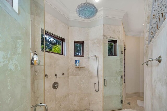 bathroom featuring a shower with door and crown molding