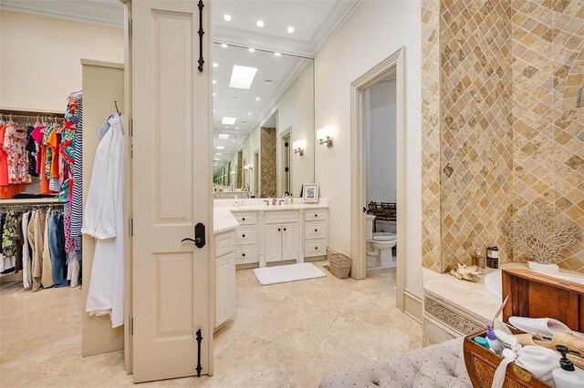 bathroom with vanity, a skylight, tile walls, and ornamental molding