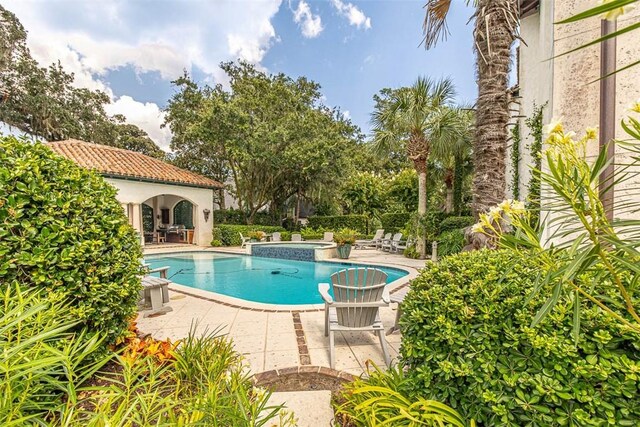 view of swimming pool featuring an in ground hot tub and a patio