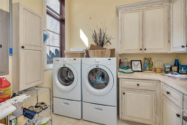 laundry area with cabinets, light tile patterned floors, and washer and dryer