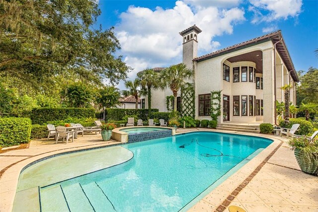 view of swimming pool featuring an in ground hot tub and a patio