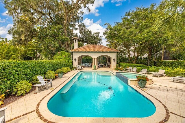 view of swimming pool with an in ground hot tub and a patio