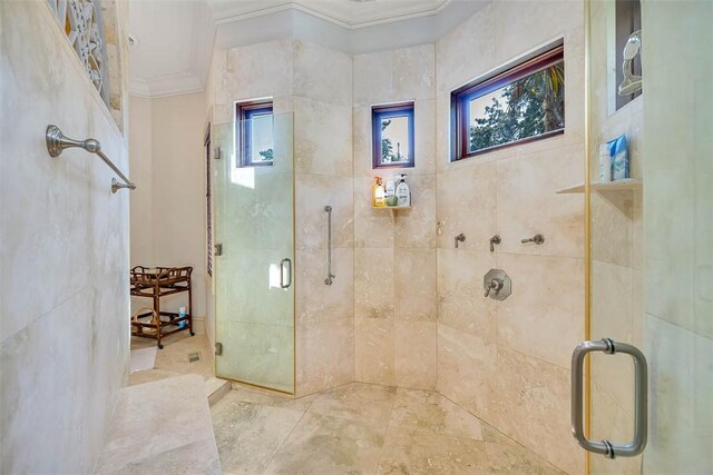 bathroom featuring a shower with shower door and ornamental molding