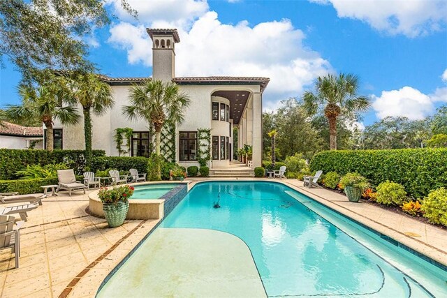 view of pool featuring a patio area and an in ground hot tub