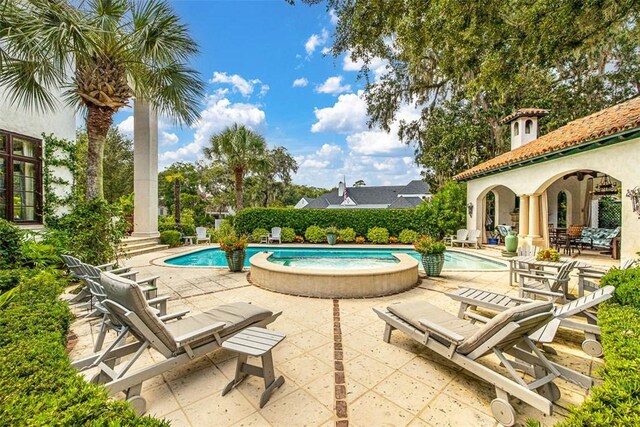 view of pool with an in ground hot tub and a patio