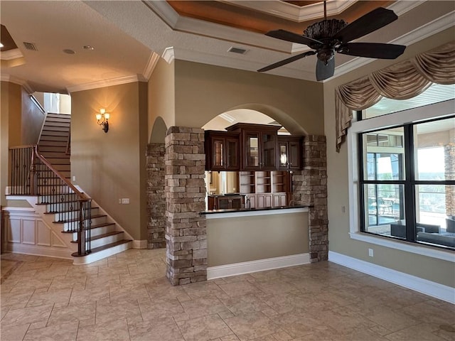 unfurnished living room with ceiling fan and ornamental molding