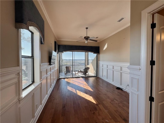 interior space with ceiling fan, dark hardwood / wood-style flooring, a healthy amount of sunlight, and ornamental molding