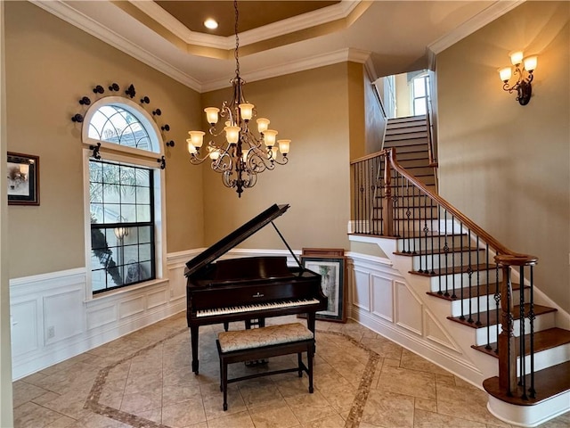 miscellaneous room with crown molding, a chandelier, and a high ceiling