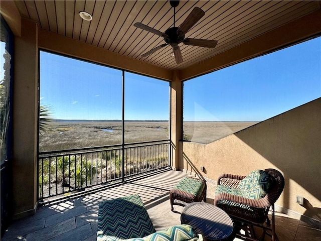 view of patio with ceiling fan and a balcony