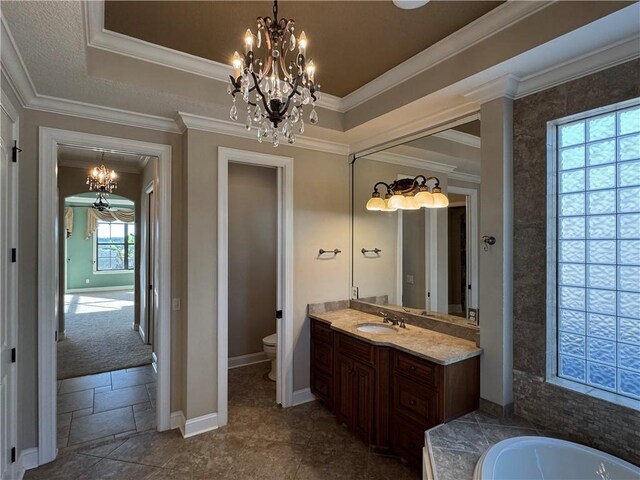 bathroom with vanity, an inviting chandelier, toilet, ornamental molding, and a tub