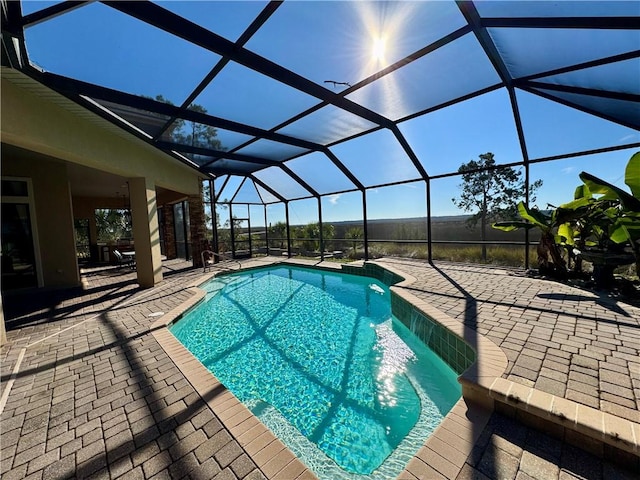 view of swimming pool featuring glass enclosure and a patio