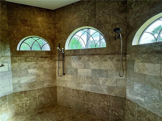 bathroom with plenty of natural light and tiled shower