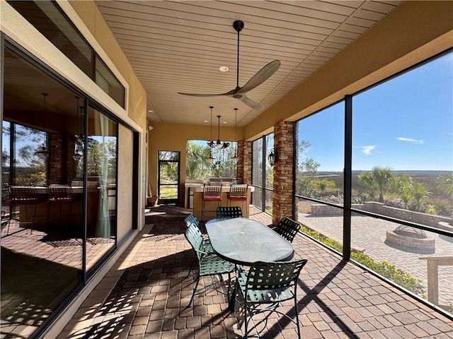 sunroom featuring ceiling fan