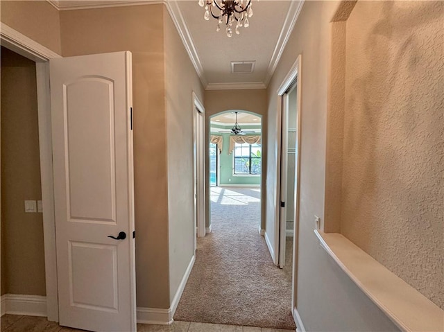 hallway featuring light carpet, a notable chandelier, and ornamental molding