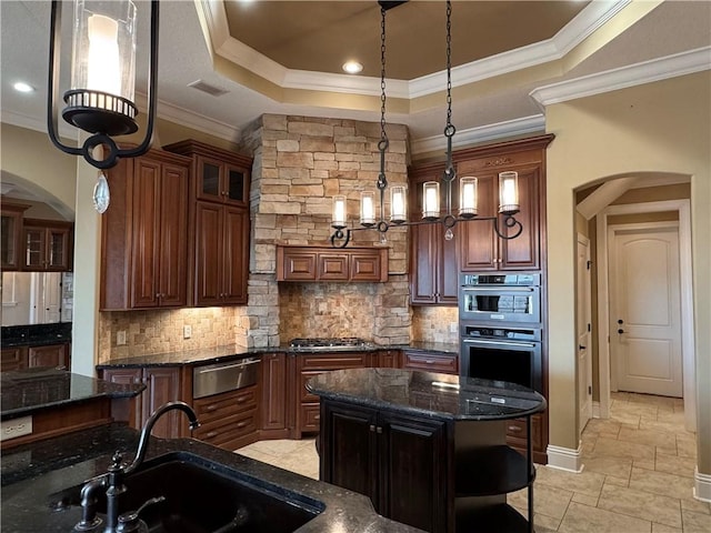 kitchen featuring a center island, a tray ceiling, ornamental molding, and sink