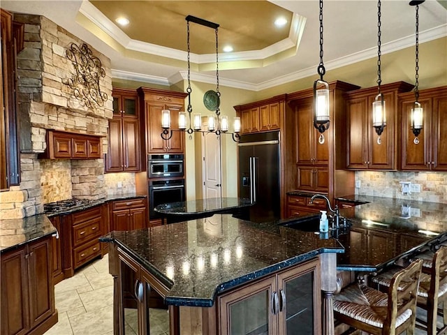 kitchen featuring ornamental molding, stainless steel appliances, a tray ceiling, pendant lighting, and a large island