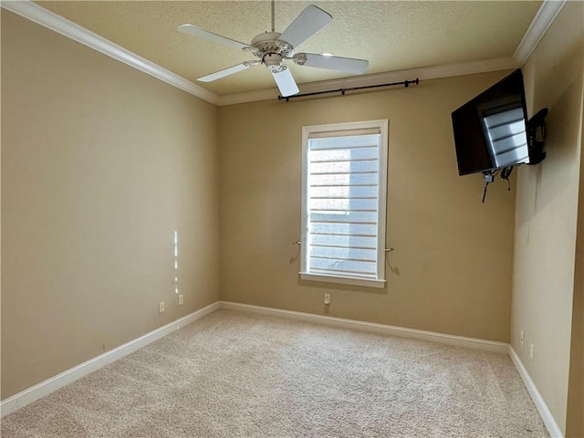 carpeted spare room featuring crown molding, ceiling fan, and a textured ceiling