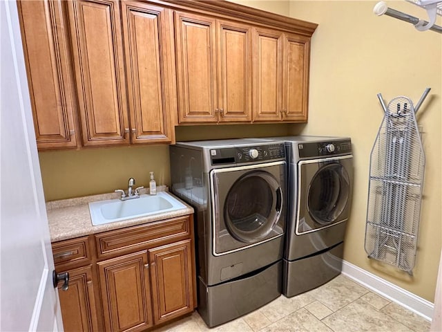 laundry area with light tile patterned flooring, cabinets, separate washer and dryer, and sink