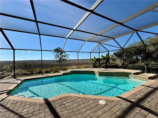 view of swimming pool featuring a lanai and a patio