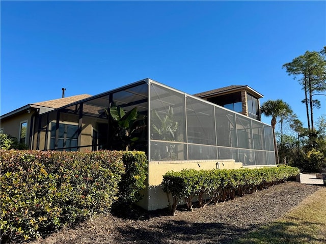 view of side of property featuring glass enclosure