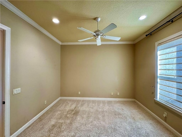 spare room with carpet, a textured ceiling, ceiling fan, and ornamental molding