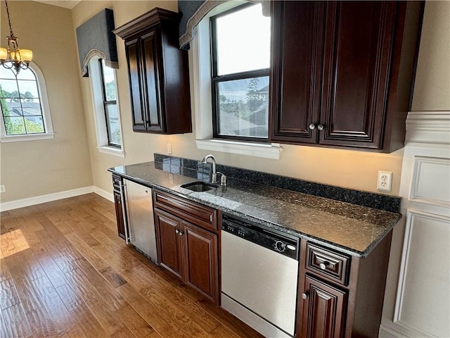 kitchen featuring hardwood / wood-style floors, dishwasher, an inviting chandelier, sink, and dark brown cabinetry