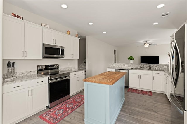 288 Chestnut Dr, Brunswick, GA 31523 - kitchen with stainless steel appliances, wood counters, ceiling fan, light wood-type flooring, and a peninsula