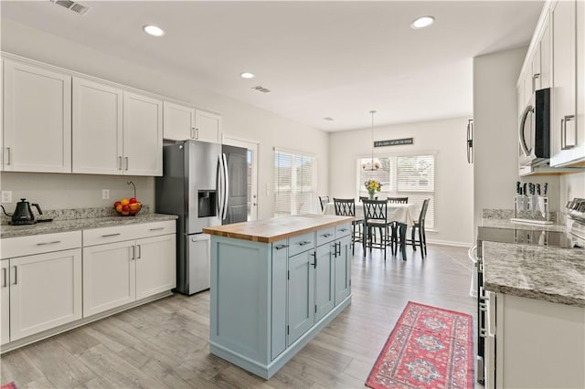 288 Chestnut Dr, Brunswick, GA 31523 - kitchen featuring wood counters, stainless steel appliances, white cabinets, light wood-style floors, and recessed lighting