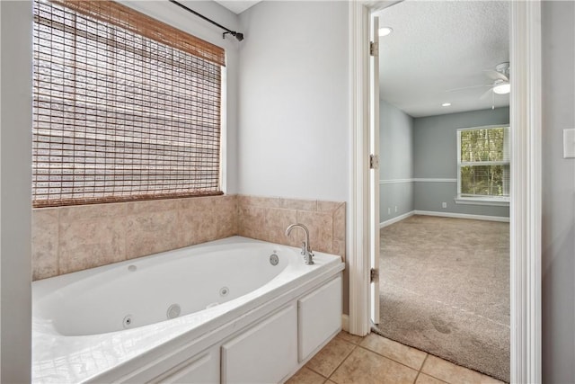 bathroom featuring tile patterned floors, ceiling fan, a bathing tub, and a textured ceiling