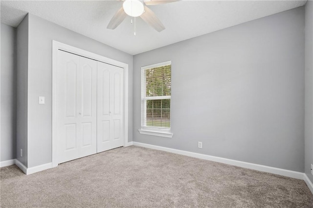 unfurnished bedroom featuring a textured ceiling, a closet, ceiling fan, and light colored carpet