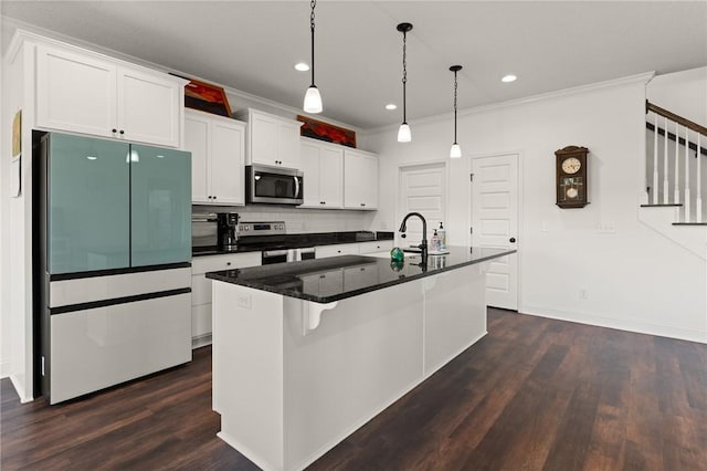 kitchen with white cabinetry, stainless steel appliances, dark hardwood / wood-style flooring, crown molding, and a center island with sink