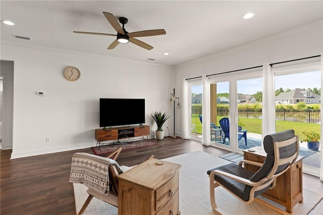 living room featuring dark hardwood / wood-style flooring, plenty of natural light, crown molding, and ceiling fan