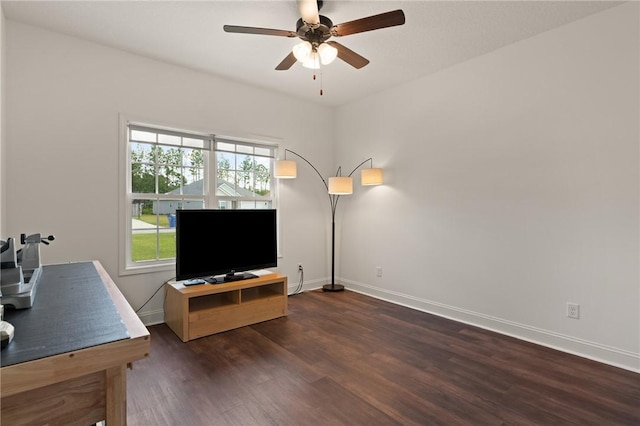 living room with plenty of natural light, ceiling fan, and dark wood-type flooring