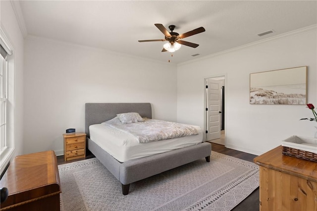 bedroom featuring dark wood-type flooring, ceiling fan, and ornamental molding