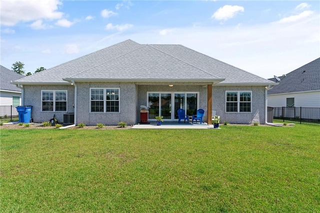 rear view of house with a lawn and a patio